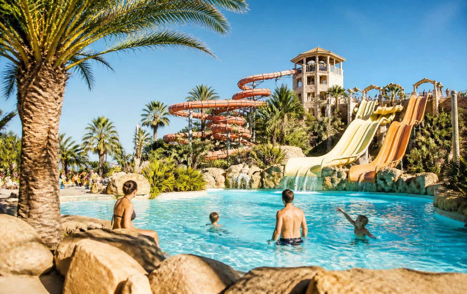 Familien zwischen Pools und großen Wasserrutschen in einem Wasserpark in Magaluf auf Mallorca