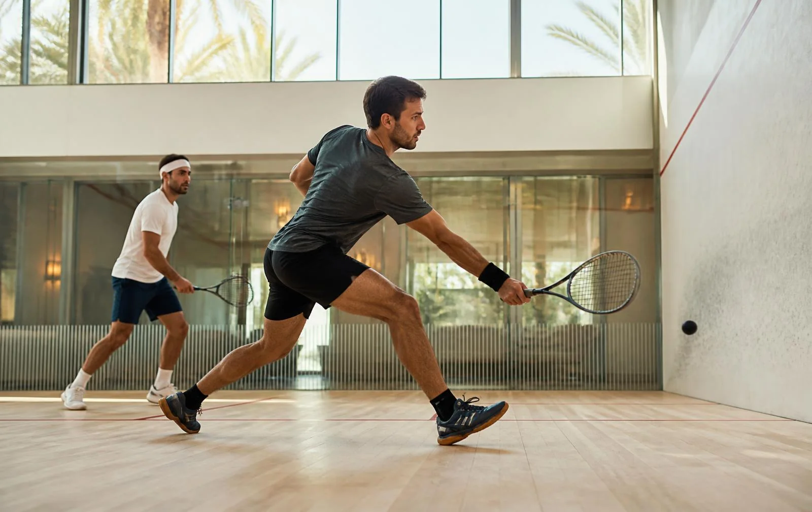 Zwei Spieler bei einem Squashmatch auf einem modernen hellen Court