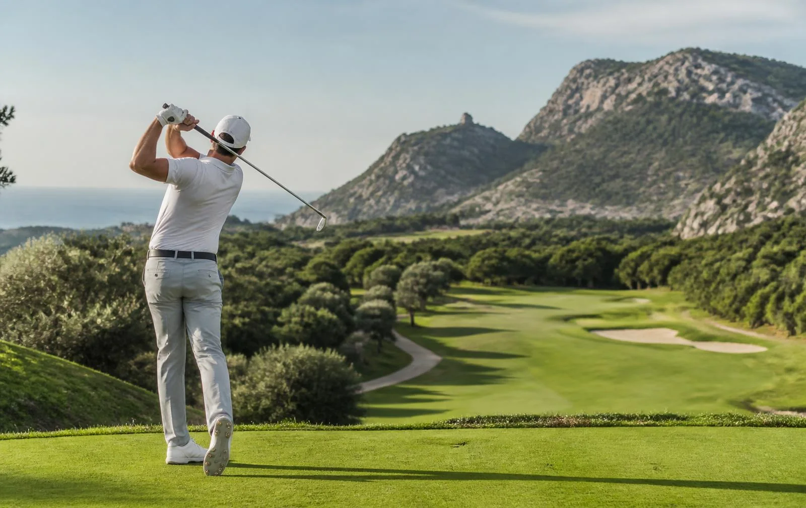 Golfer auf einem mediterranen Golfplatz auf Mallorca mit Bergen und Meerblick