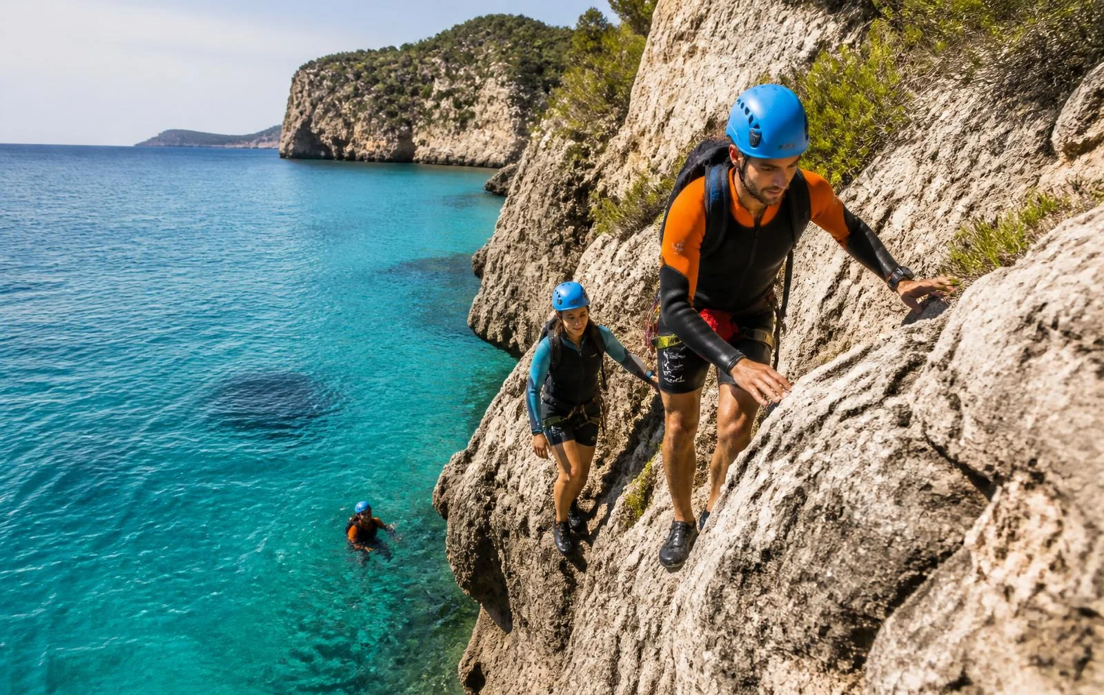 Geführte Coasteering-Gruppe an einer Felsküste mit türkisem Wasser auf Mallorca