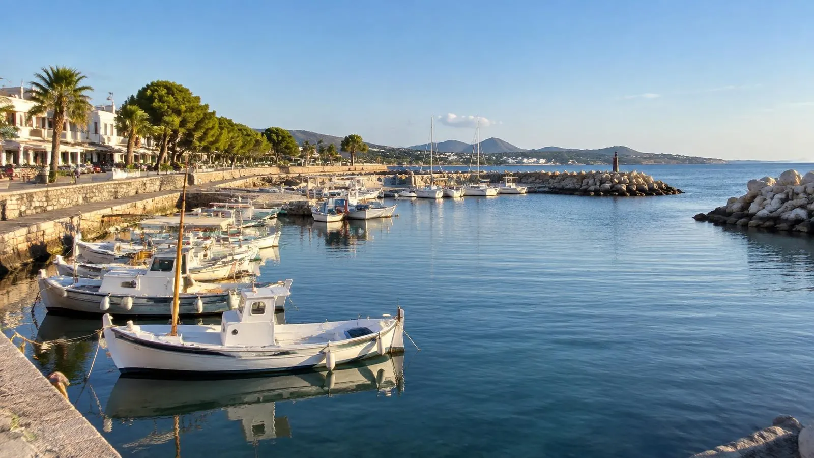 Kleiner Fischerhafen von Cala Bona an der Ostküste Mallorcas mit Booten, Mole und Uferpromenade