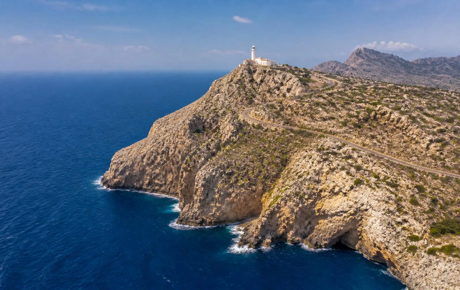 Steilküste des Cap de Formentor mit Leuchtturm auf der Landzunge und tiefblauem Meer im Norden Mallorcas