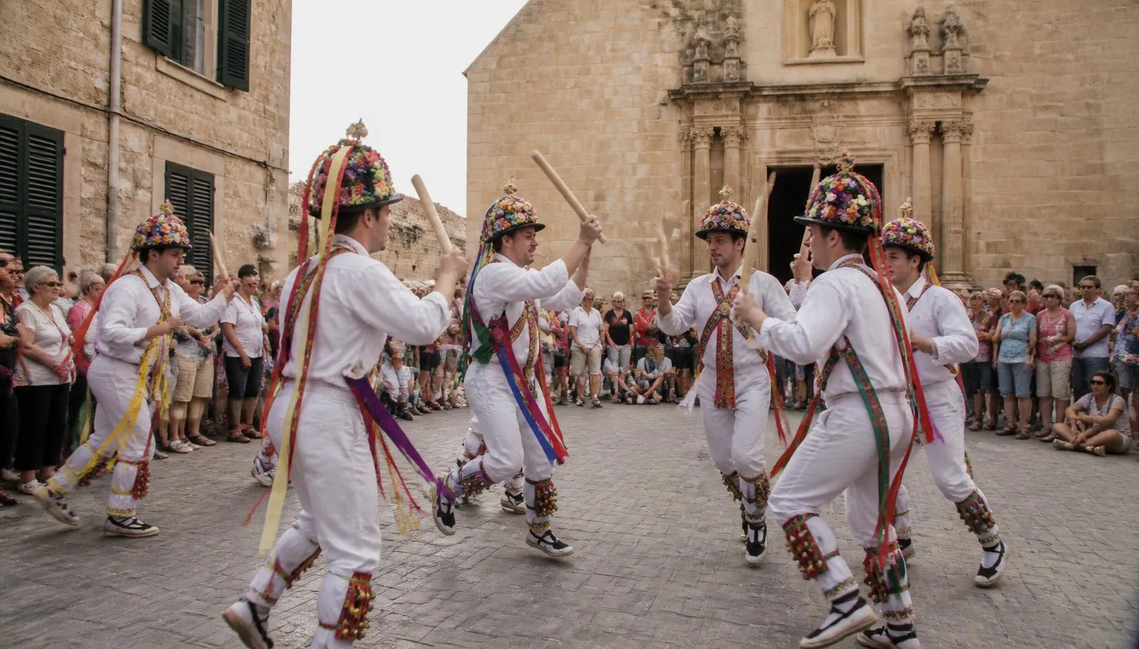 Cossiers-Tänzer in weißer Tracht mit Bändern und Blumenhüten beim Ritualtanz in Montuïri auf Mallorca