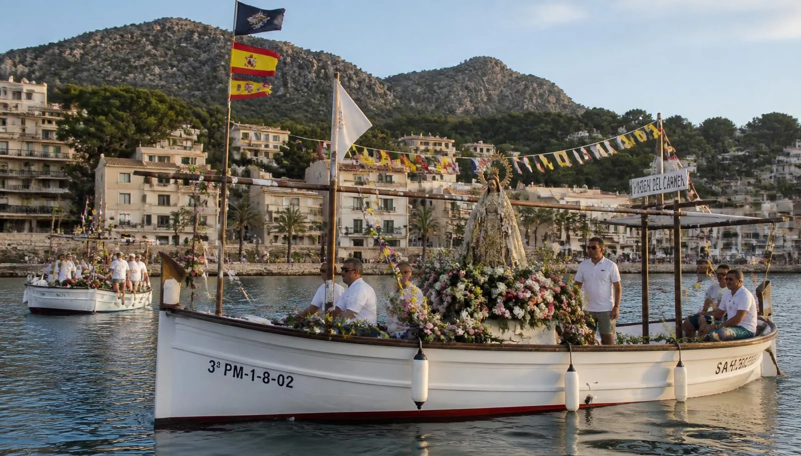 Mit Blumen geschmücktes Fischerboot mit Marienstatue bei der Bootsprozession im Hafen von Port de Sóller